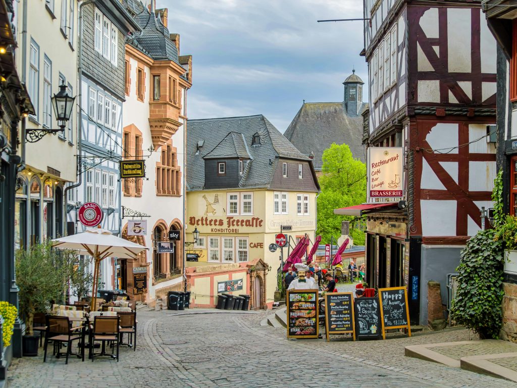 Picturesque view of a cobblestone street in Marburg's old town, showcasing historic architecture and cafes.